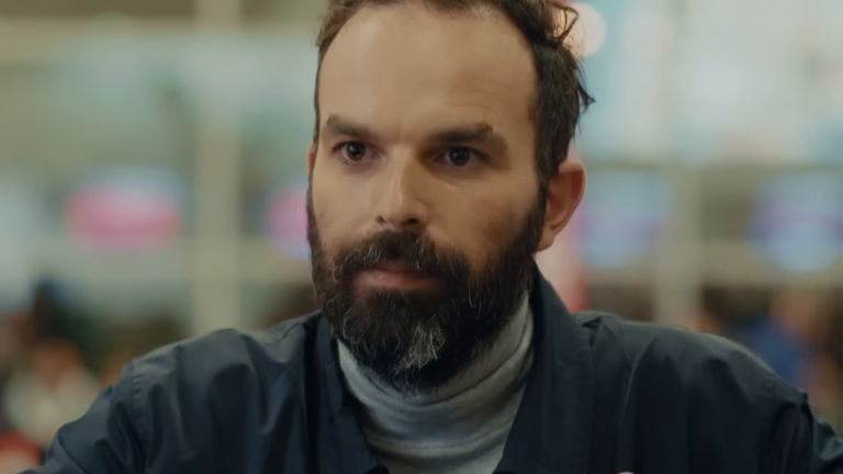 Der Reisende hört der Mitarbeiterin am Check-in-Schalter in Iberias Kampagne „El dilema de Navidad“ zu